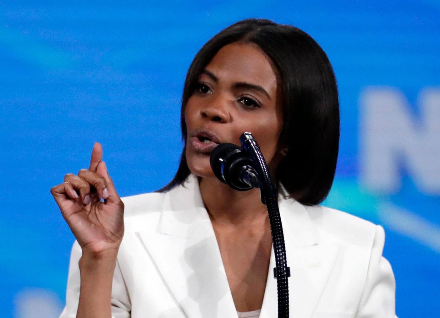 Candace Owens Farmer in a white jacket at the podium